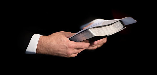 Hands holding a Bible and sermon notes. man priest pastor minister 262972 PD 600x400